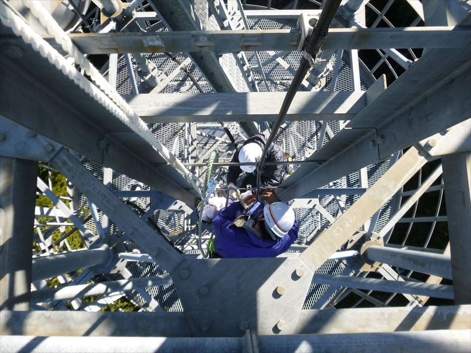 長島ダム管内の中継所における鉄塔の垂直ラダーでの作業状況
